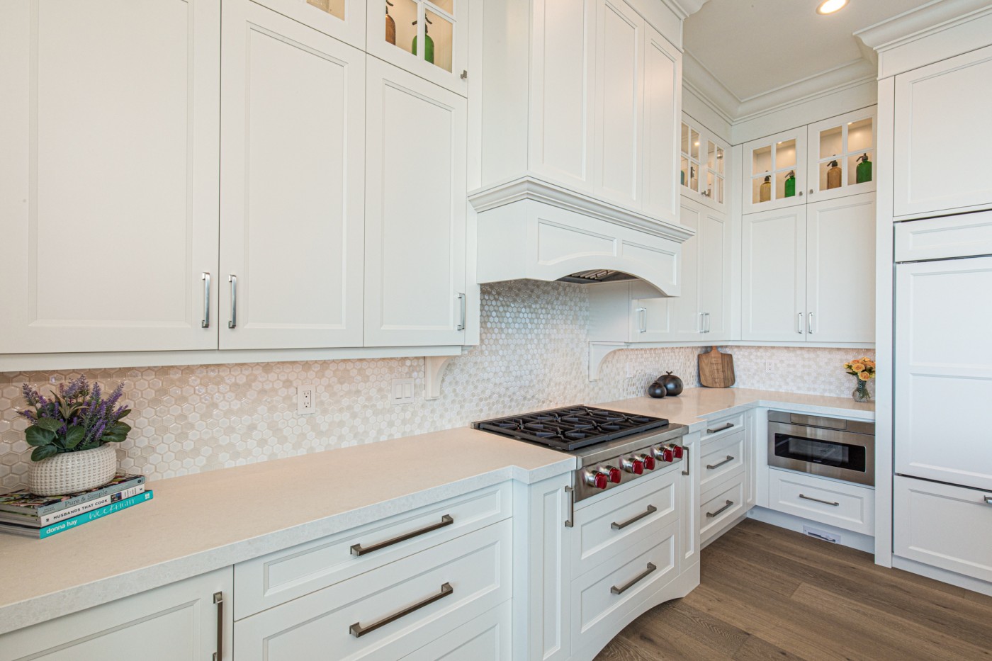 Bright white kitchen with custom cabinets and light countertops, illustrating planning a kitchen renovation with cabinetry designed before surfaces.